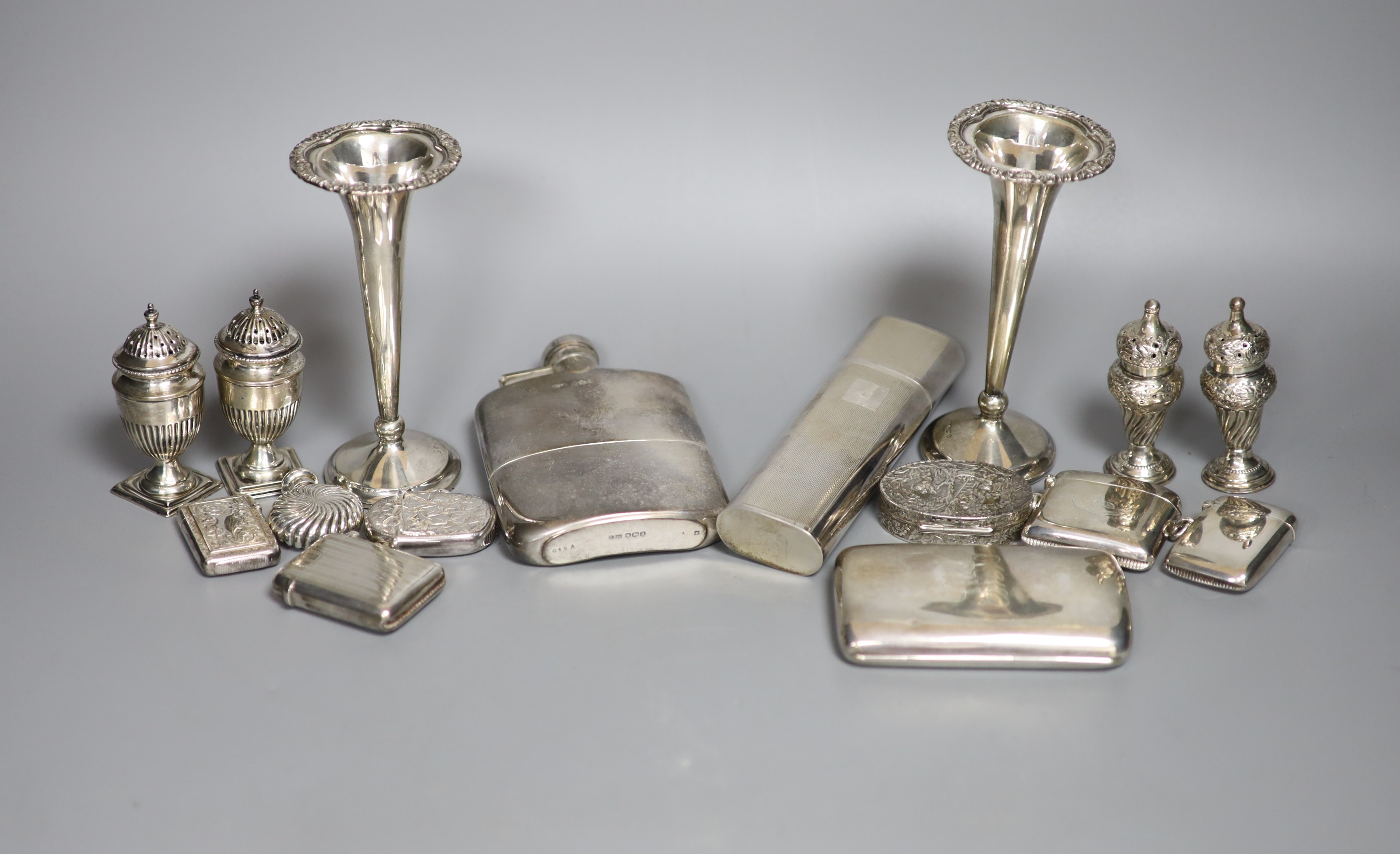 A group of assorted silver including two hip flasks, two spill vases, condiments, vesta cases, cigarette case, scent flask etc.